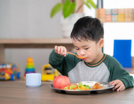 Asian student take a lunch in class room by food tray prepared by his preschool, this image can use for food, school, kid and education concept